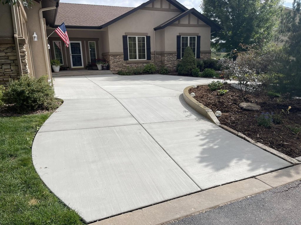 A picture of a home with a fresh concrete driveway.